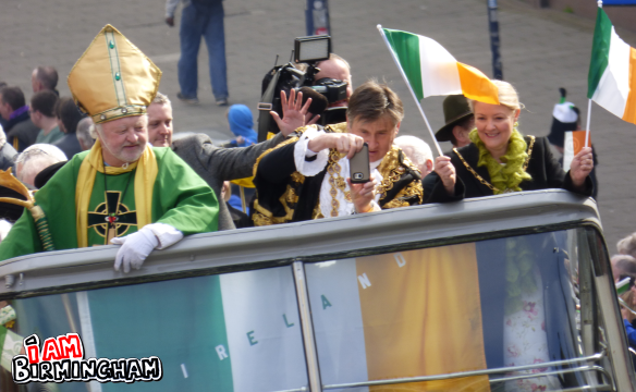 The Lord Mayor of Birmingham Councillor Carl Rice grabs a photo from the top of a double decker bus during the St patrick's Day parade (Photograph: Rangzeb Hussain)